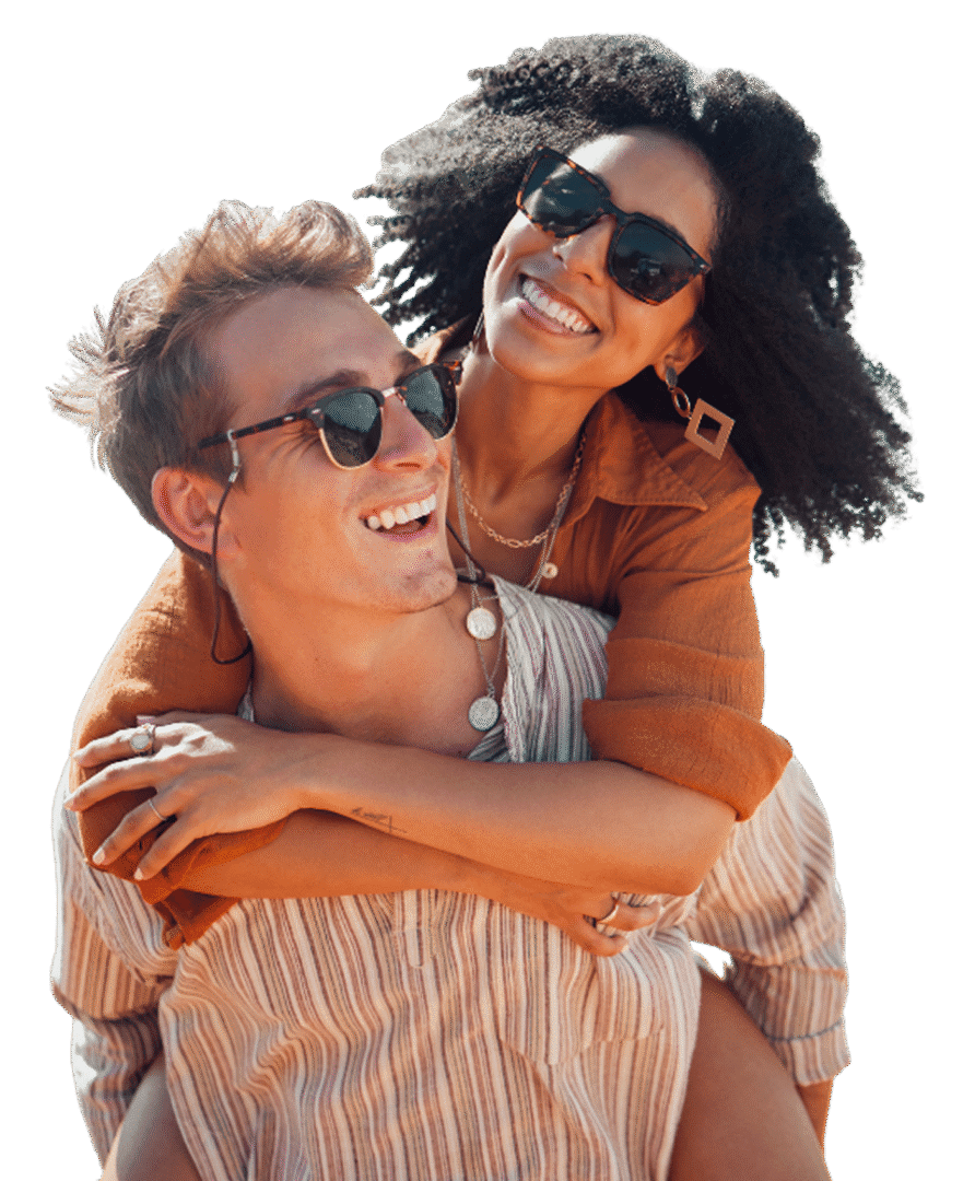Smiling couple wearing sunglasses, embracing outdoors.