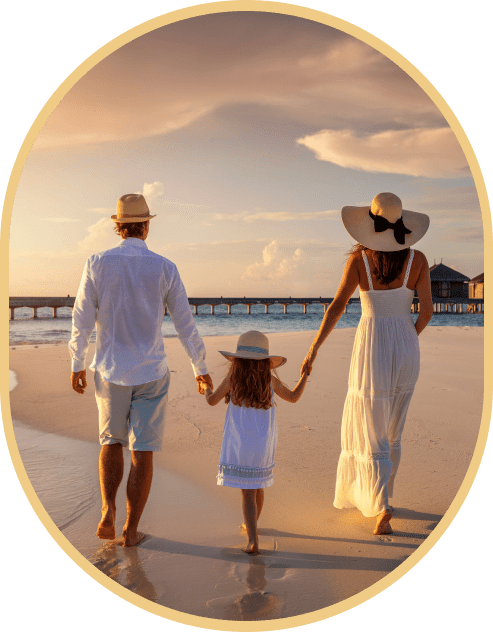 Family walking on beach at sunset.